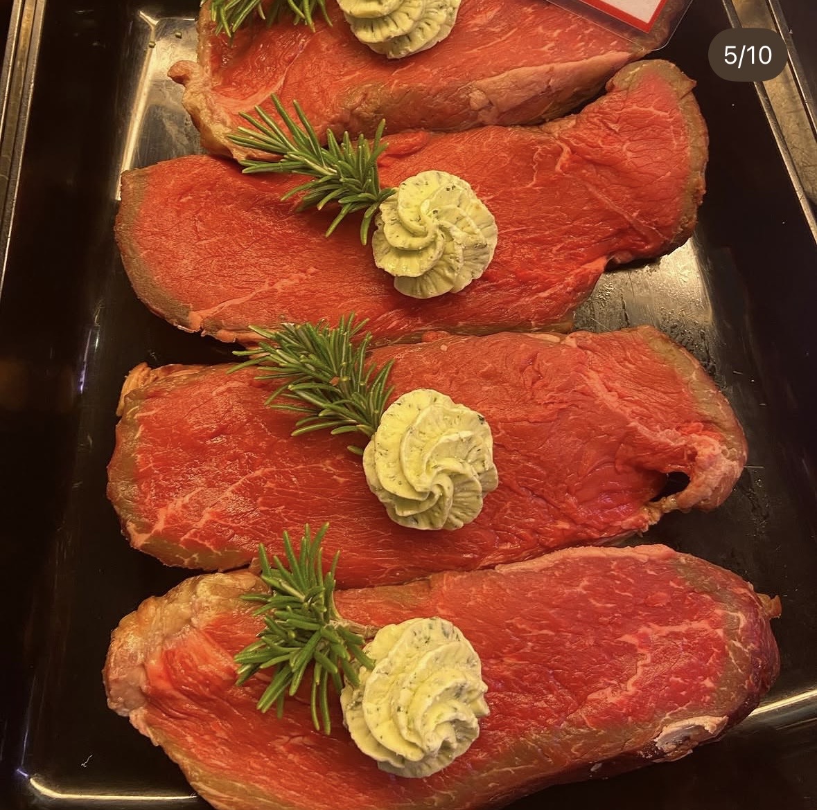 Frisch vorbereitete Steaks mit Kräuterbutter und Rosmarin